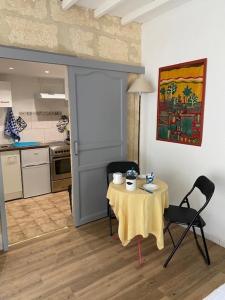 索米耶尔Charmant studio à 2 pas du centre historique的配有桌椅和厨房的房间