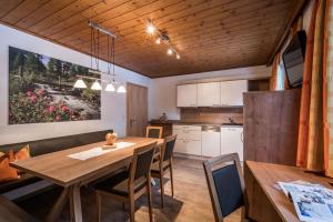 迈尔霍芬Landhaus Gredler的厨房以及带木桌和椅子的用餐室。