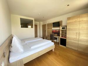 滨湖波德斯多夫赫林德湖滨酒店的卧室配有一张白色大床和一张书桌