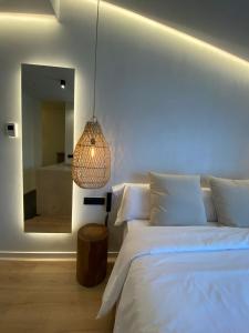 埃斯·梅卡达尔S´Estancia Suites的卧室配有白色的床和镜子