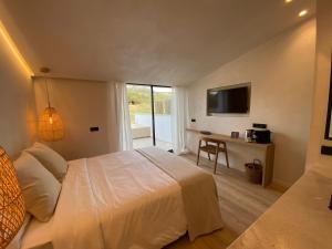 埃斯·梅卡达尔S´Estancia Suites的一间卧室配有一张床、一张书桌和一台电视