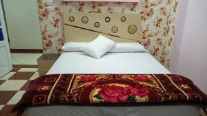 亚历山大شقة فندقية اسكندر ابراهيم的一间卧室配有一张带花卉毯子的床