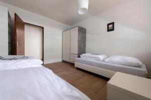格罗瑙Workers Home- Central - 8 single box spring beds - near Enschede的配有白色墙壁和木地板的客房内的两张床