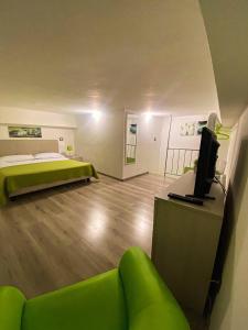 贾迪尼-纳克索斯Naxos Apartments的客房设有床、沙发和电视。