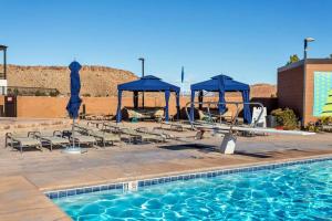 圣乔治Resort Villa 4 - LUXURY VILLA, POOL VIEW, GAMES GALORE, TOP LEVEL! YEAR ROUND HEATED POOL & HOT TUB!的一个带椅子的游泳池和一个凉亭