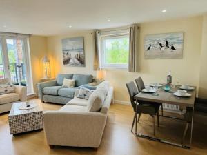 巴洛赫Riverside View Penthouse in Balloch, Loch Lomond的客厅配有沙发和桌子