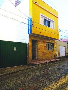 阿帕雷西达Pousada Jesus Misericordioso的建筑旁街道上的黄色建筑