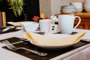 韦斯特波特Plougastel House B&B的桌子上摆有盘子和杯子,餐具