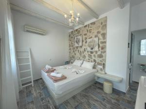 纳克索乔拉BURGOS BARRIO的一间卧室设有一张床和石墙