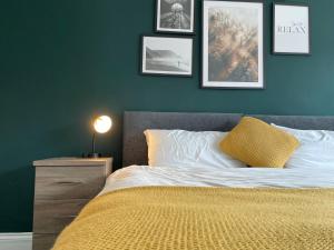 杜伦Durham 3 Bedroom House With Parking的一间卧室配有一张带黄色毯子和墙上照片的床。