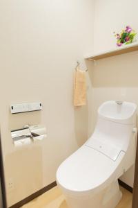 东京My Home in Tokyo - Vacation STAY 73228v的浴室设有白色卫生间,墙上挂有鲜花。