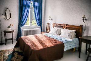 伊马特拉Neitsytniemen Kartanohotelli的一间卧室配有一张带蓝色窗帘的床和一扇窗户