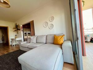 波尔蒂芒My Place的客厅配有灰色的沙发和黄色的枕头。