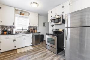 堪萨斯城3 Bedrooms House in Waldo Kansas City的厨房配有白色橱柜和不锈钢冰箱