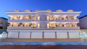 马尔马里斯L'olive homes的一座白色的大建筑,前面设有一个游泳池