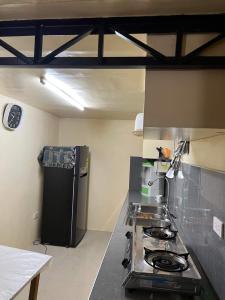 碧瑶Serenity House的厨房配有炉灶和黑冰箱。