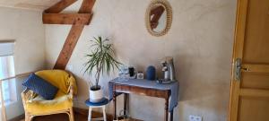 Saint-Sylvestre-sur-LotLe Coq en Repos的配有桌子、椅子和镜子的房间