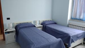拉迪斯波利Villa Grazia的配有蓝色棉被的客房内的两张床