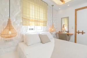 纳克索乔拉Blue Sky Summer的白色卧室配有白色的床和两盏灯。