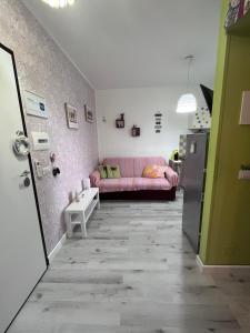 科帕内罗Appartamento Affaccio sul mare, Baia di Copanello的客厅配有粉红色的沙发和冰箱
