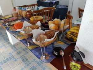 坎波斯杜若尔当Pousada Vila Tio Lé的一张桌子,上面有几个篮子的面包和其他食物