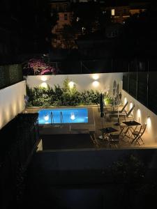 里斯本Saldanha Pool & Garden的夜间游泳池,配有椅子和灯