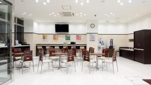 北九州Toyoko Inn Kokura eki Shinkansen guchi的大型用餐室配有桌椅