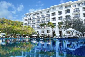 立咯海滩The Danna Langkawi - A Member of Small Luxury Hotels of the World的大楼前设有游泳池的酒店