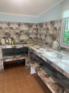 罗勇NADOHN2 San Fan Homestay的厨房配有带水槽和瓷砖的柜台。