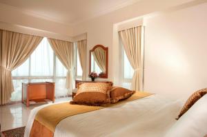 雅加达The Residences at Puri Casablanca的一间卧室配有一张带镜子和钢琴的床