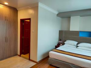 仰光联合大酒店（阿弄店）的一间卧室设有一张大床和一扇红色的门