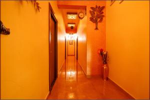 钦奈FabHotel Vijaylakshmi Stay Inn的走廊上设有黄色的墙壁和一扇门,花瓶