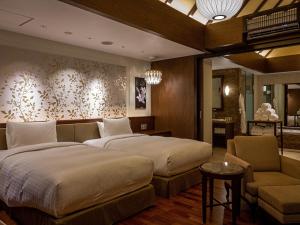 那霸Okinawa EXES Naha的一间卧室配有两张床、一张沙发和一把椅子