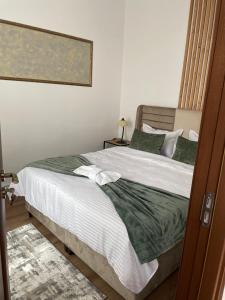 锡比乌Norderney Apartments的一间卧室配有带白色床单和绿色枕头的床。