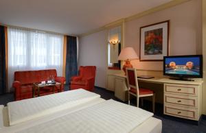 巴特乔京帝王酒店的酒店客房配有一张床和一张书桌及一台电视