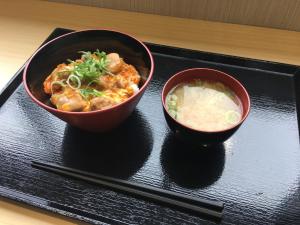 尼崎市阪神神崎前根Y‘s酒店的黑盘上装有筷子的两碗食物