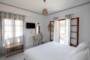 Ágios KonstantínosIro's Residence的一间卧室配有一张床、一张书桌和一台电视