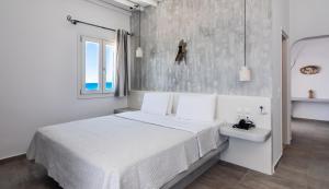 阿波罗尼亚塔尼亚米洛斯旅馆的白色卧室设有床铺和水槽