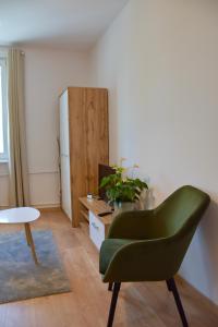 科宁Nest Centrum Konin的客厅配有绿色椅子和冰箱