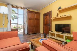 马略卡岛帕尔马Villa El Terreno的客厅配有橙色家具和平面电视。
