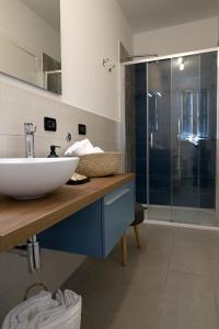 拉文纳Domus Silvana Apartments的一间带水槽和玻璃淋浴的浴室