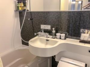 名古屋HOTEL LiVEMAX BUDGET Nagoya Taikodori的浴室配有盥洗盆、卫生间和浴缸。