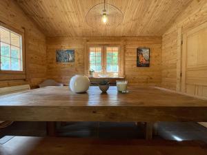 克松吕-隆日梅Le Refuge de Belbriette, chalet au coeur de la nature avec spa的木墙客房内的大木桌