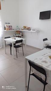 圣尼科拉阿尔切拉B&B VANNEFORA的一间设有白色桌椅的用餐室