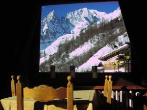 库马约尔阿索托丽亚酒店的电视,享有雪覆盖的山脉美景