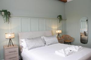 哈德斯菲尔德文化遗址服务式套房-服务式公寓酒店的卧室配有一张带两盏灯和镜子的白色床。