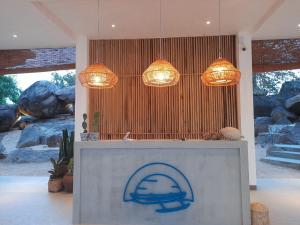 阿鲁甘湾Oruwa Boutique Villas的大堂设有2个吊灯和1个带标志的柜台