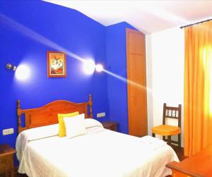 坎波德克里普塔纳Hostal Restaurante Ego's的一间卧室设有蓝色的墙壁和一张床