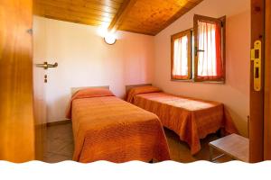 索威拉托玛里纳Freedom Village的客房设有两张带橙色床单的床和窗户。