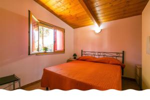 索威拉托玛里纳Freedom Village的一间卧室配有带橙色床单的床和窗户。